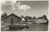 Hamnen med bodar. I bakgrunden till höger en ladugård.
