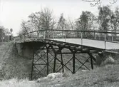Bro över järnvägen vid Åsarna. Balkbro med stativ av hopfogade räler i tre spann.