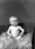 Ateljébild. Ett spädbarn på en fårfäll. Enligt Walter Olsons journal är bilden beställd av fru A Olsson.