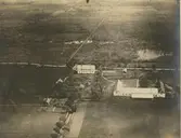 Halltorp från luften. Vid vägen mangården med huvudbyggning och två flyglar. Hitom byggningen trädgård varifrån en väg löper i rak riktning ned mot sundet. Trädgården är terasserad. Mitt för mangården på andra sidan vägen även en trädgårdsanläggning, tidigare en köksträdgård. Till höger ladugården, som nybyggdes under ägaren Perssons tid.