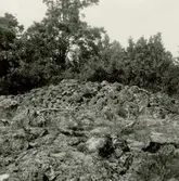 Gravfält på berget 300 meter sydost om Lund, mitt för Gladhammars kyrka. Röse mitt i gravfältet.