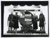 Kappmagasinets skyltfönster. 
Smid medan järnet är varmt! Ännu kan ni få kappmagasinets kvalitetskappa till billiga priser.