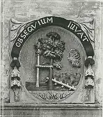 Stenrelief på rådhusets huvudfasad, huggen av Jakob Schultz och uppsatt 1688.  Obseqvium iuvat betyder foglighet/lydnad räddar/hjälper.