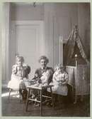 Sven Sundbergs fru med två flickor och dockor i en barnkammare.