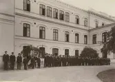Huvudbyggnadens framsida med eleverna uppställda till utmarsch.