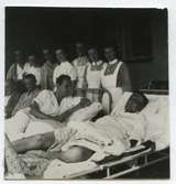 Tyska sjömän som överlevt minsprängningen vid Össby i sjukhussängar på altanen med personal.