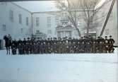 En grupp militärer, kanske skarpskyttar, uppställda på inre borggården på Kalmar slott vintern 1914.