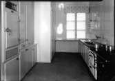Hypermodernt kök från 1940 med kylskåp och rostfri diskbänk.