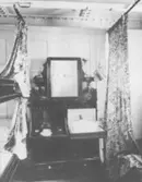 Titanic.
Tvåmanshytt med toalettmöbel och blommiga förhängen.