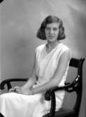 Ateljébild på en kvinna i halsband och armbandsur. Enligt Walter Olsons journal är bilden beställd av Margareta Antoni.