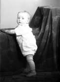 Ateljébild på ett barn i lekdräkt. Enligt Walter Olsons journal är bilden beställd av Egon Andersson.