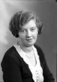 Ateljébild på en kvinna i halsband och jumper. Enligt Walter Olsons journal är bilden beställd av Vera Andersson.