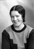Ateljébild på en kvinna i jumper. Enligt Walter Olsons journal är bilden beställd av Anna-Lisa Mattsson.