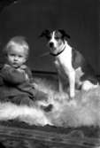Ateljébild på en pojke och hund. Enligt Walter Olsons journal är bilden beställd av fru H Arvidsson.