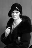 Ateljébild på en kvinna i hatt och kappa med pälskrage. Enligt Walter Olsons journal är bilden beställd av Elisabet Andersson ifrån Kalmar.
