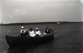 En man, tre kvinnor och två barn på en båtutflykt.