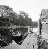 Mannen förtöjer båten vid bryggan.