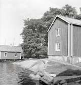 Hus och sjöbod i bakgrunden på Älö.