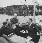 Gösta Åhlén tredje personen från vänster, Roy Hähnel längst till höger i segelbåt med en flaska konjak.