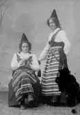 Två damer i folkdräkter, troligen Rättviksdräkten.