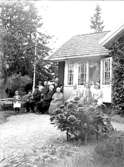 Härlunda socken. Gotland.
Östgöta-främmande på Gotland, Härlunda. C:a 1932.
Karin Andersson, Ellen Andersson, Emil Jansson med dottersonen Erik Andersson i knäet,  hans hustru Alma Jansson, bakom henne Arvid Andersson, Carl Magnus Andersson, hans hustru Eva Vilhelmina Andersson, bakom henne Berta Andersson, Anita (dtr t. Carl Magnus o Eva Vilhelmina), Kerstin, Elisabeth Jansson, systrar till Eva Vilhelmina), Elsa Andersson samt stående i dörren, Eric Jansson (bror till Eva Vilhelmina) med systerdottern Brita Andersson i famnen.