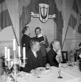Skara Manskörs 30-årsjubileum, 1951.
Körens ordförande Sam Magnusson mottager vänorten Eidsvolls manskörs gåva. Sittande stadsfullmäktiges ordförande Rudolf Andersson och Västergötlands sångarförbunds ordförande landshövding Richert.