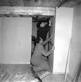 Skara Fotoklubb.
Fotoklubbens lokal i Teaterhusets källare. Holger Johansson och Nils Bäckström i reparationstagen.