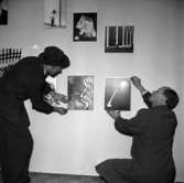Skara Fotoklubb.
15-årsjubileet 1956. Holter Wilson och Stig Rehn hänger bilder.