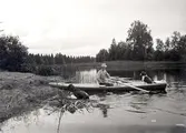 Man med två hundar i en flatbottnad eka på ån Nossan.