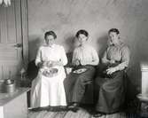 Tre kvinnor sysselsatta med att skala äpplen och mala kaffe.
Kvinnan i mitten är Ebba Bergman och till höger hennes mamma Julia Bergman på Rudet.