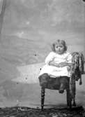 Ateljé. Liten flicka i stol.Fotograf:Ellen Kock? Axel Lundbäck m.fl.Gullspångssamlingen.Bilder från Gullspång med omnejd.