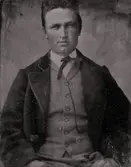 Okänd man iklädd fluga, väst och kavaj.