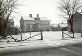 Bostadshus och staket i vinterlandskap från Södra vägen.