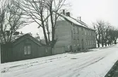 En stuga och hyreshus på Gripgatan i Kalmar under vintertid.