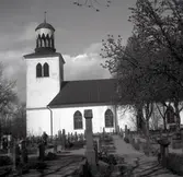 Kyrkan i Vena socken. En man sköter om kyrkogården.