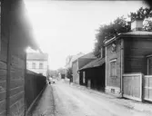 Gefle Arbetsstuga för barn, Kungsgatan 31. Gatan är Arbetshusgatan. Arbetsstugan är tredje huset på höger hand, i hörnet av Kungsgatan. Längst i bakgrunden skymtar Lärarhögskolan, då Dövstumsskolan.