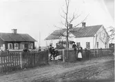 Hjortas i Brunn före det att bryggstugan byggdes om till banklokal.
Kommunalnämndens ordförande Erik Lund som syns på bilden ägde och bodde i det vita huset.