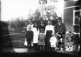 Familjegrupp vid husgavel.
