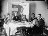 Ruth, Sara, Josef och Tyra med sällskap hemma vid matbordet, Östhammar, Uppland
