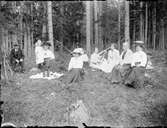Man och kvinnor på picknick i skogen, Östhammar, Uppland