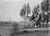 Linköping från Ramshäll. I fonden ståtar den vid tiden relativt nyuppförda Linnéskolan. I grönskan till vänster om barnen skymtar villa Boiro, uppfört av telegrafkommisarien Emrik Wenström 1898.