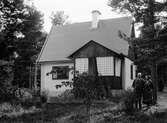 Kvinna och man vid villa, sannolikt Uppland, 1934