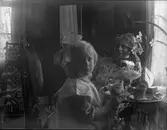 Kvinna och barn med bricka med fika. Kvinnan är troligtvis Mimmi Stenbäck, syster till fotografen Nanny Ekström.