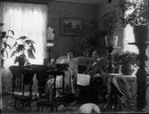 Man och kvinna i sallong. Mannen läser Östgöta corren.