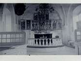 Interiörbild av koret i okänd kyrka. Altarring, altare, altartavla.