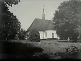 Djurö kyrka med lummig kyrkogård.