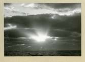 Bilden föreställer horisonten, där solens strålar skiner igenom ett molntäcke. Bilden är tagen i samband med minfartyget Älvsnabbens långresa 1966-1967.