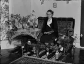 Kvinna i bostadsmiljö omgiven av blommor, Östhammar, Uppland