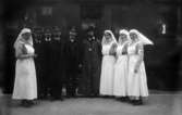 Röda Korset, invalidutväxlingen 1915-1917, under första världskriget. Några rödakorssystrar, SJ-anställda samt el äldre man i lång rock vid ett tåg.