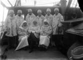 Röda korset, 1914-1918 Män och kvinnor i rödakorsuniform på ett båtdäck.